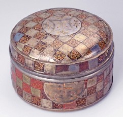 קופסה לקטורת (קוגו), דוגמת משבצות 

אמן אנונימי  

עץ מצופה לכה, נאשיג'י ושיבוץ כסף 

המאה ה־17 

קוטר: 6.3 ס"מ